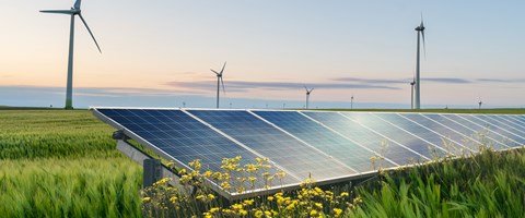 Photovoltaik-Anlage auf Agrarfläche mit Windkraftanlagen im Hintergrund Photovoltaik-Anlage auf Agrarfläche mit Windkraftanlagen im Hintergrund