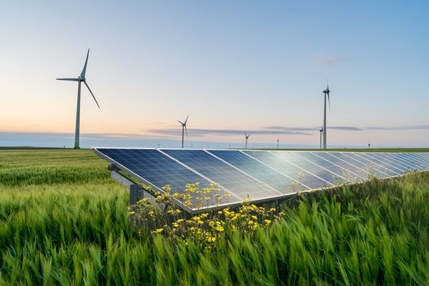 Photovoltaik-Anlage auf Agrarfläche mit Windkraftanlagen im Hintergrund Photovoltaik-Anlage auf Agrarfläche mit Windkraftanlagen im Hintergrund