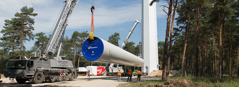 Ein Bauelement für den Turm eines Windkraftrads im Windpark Eichow wird von einem Kran gehalten Ein Bauelement für den Turm eines Windkraftrads im Windpark Eichow wird von einem Kran gehalten