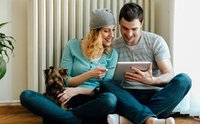 Mann und Frau sitzen mit Hund vor einem Heizkörper Mann und Frau sitzen mit Hund vor einem Heizkörper